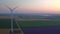 Aerial view of a landscape with lavender field and wind turbine at sunset