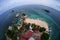 Aerial view of landscape from top lighthouse with several boats, coconut tree and coral rock surrounded turquoise water in fishbow