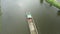 Aerial view of large cargo barge moving along the river. Cargo ship or tugboat transporting sand or raw material.