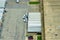 Aerial view of large commercial loading bay with many delivery trucks unloading and uploading retail goods for