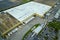 Aerial view of large commercial loading bay with many delivery trucks unloading and uploading retail goods for