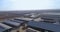 aerial view of large farm with cows in stalls in village, view from above of agricultural fields and many bales of hay