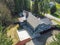 Aerial view of Large grey home surrounded by trees