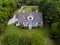 Aerial view of large home with on wooded grassy property
