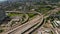 Aerial view of large multilane highway intersection in town. Cars smoothly driving in lanes through multilevel transport