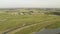 Aerial view of large river surrounded by agriculture fields against grey cloudy sky. Action. Aerial view of rural