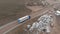 Aerial view of a large truck with a trailer driving along a dirt road in search of a place for a U-turn in the vicinity