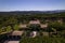 Aerial view of a large villa and a backyard full of trees and vegetation on a sunny day