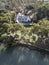 Aerial view of large waterfront luxury home on wooded lot