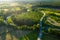 Aerial view of Latvian rural landscape with a winding river, forests and country roads at sunset