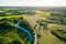 Aerial view of Latvian rural landscape with a winding river, forests and country roads at sunset