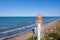 Aerial view of lighthouse with red top and white base. Blue sky and sea. Pape lighthouse