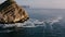 Aerial view of little fishing boat crossing San Martin Cape in Spain.