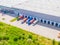 Aerial view of a logistics park with warehouse, loading hub and many semi trucks with cargo trailers standing at the ramps for