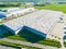 Aerial view of the logistics park with warehouse, loading hub and many semi trucks with cargo trailers standing at the ramps for