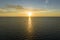 Aerial view of lonesome white yacht at sunset floating on sea waves with ripple surface. Motor boat recreation on ocean