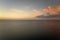 Aerial view of lonesome white yacht at sunset floating on sea waves with ripple surface. Motor boat recreation on ocean