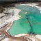 Aerial view of the long boom of a suction excavator in a quartz quarry for the excavation of white sand.