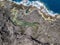 Aerial view of Los Charcones, Lanzarote. Spain. Water pool on a lava soil. Bathers. Swimming.