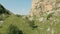 Aerial view of low flying mountain gorge between rocks above trees