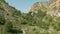 Aerial view of low flying mountain gorge between rocks above trees