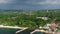 Aerial view of a lush coastal town in Jamaica with a scenic coastline and distant hills. Experience the vibrant and