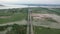 Aerial view of lush green area with water body and cars moving on the road