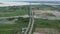 Aerial view of lush green area with water body and cars moving on the road