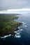 Aerial view of a lush green and blue landscape featuring a vast expanse of ocean and lush green land