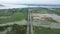 Aerial view of lush green landscape with water body and cars moving on the road