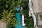 Aerial view of luxury hotel with straw roof villas and pools in tropical jungle and palm trees. Luxurious villa