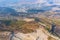 Aerial view of machine excavator trucks dig coal mining or ore with black grunge ground in quarry with mountain hills. Nature