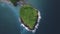 Aerial view of magnificent small islet full of greenery lush in the blue ocean.
