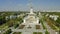 Aerial view on main central pavilion of VDNKh exhibition in Soviet Union style with columns, golden decoration among flowers beds