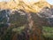 Aerial view of majestic european Alps mountains covered in evergreen pine forest in autumn