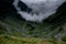 Aerial view of the majestic fog-covered green mountains and winding Transfagarasan road