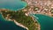 Aerial View of Makarska Riviera with Serene Marina and Verdant Isle. Overlooking harbour, urban life thrives beside lush
