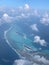 Aerial view of the Maldives in the turquoise water of the Indian Ocean from the porthole of a local airlines plane