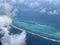 Aerial view of the Maldives in the turquoise water of the Indian Ocean from the porthole of a local airlines plane