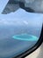 Aerial view of the Maldives in the turquoise water of the Indian Ocean from the porthole from under the wing of a local airlines