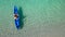 Aerial view of man in floating kayak. kayaking out from beach on clear blue sea. right side copy space. water sports and summer