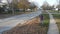 Aerial view of a man raking up fallen autumn leaves on a suburban street. American suburban neighborhood.Residential single family