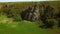 Aerial view of man solo free climbing on cliffs. Male climb the rock without safety harness and ropes. Climber in the