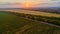 Aerial view of a meadow and a beautiful plantation, during sunset