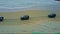 Aerial view military jeeps drive along sand ocean beach