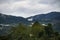 Aerial view of mist, cloud and fog hanging over a lush tropical rainforest after a storm. Treetops of mountain range with fog