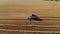 Aerial view of modern combine harvesting wheat on the field. Flying directly above combine. Top view. Agriculture scene.