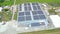 Aerial view of modern storage warehouse with solar panels on the roof. Logistics center in industrial city zone from drone view.