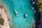 Aerial view of moored rib boats with swimmers at the turquoise colored Aegean Sea