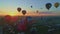 Aerial view of a morning launch of hot air balloons at a hot air balloon festival at sunrise on a sunny summer day